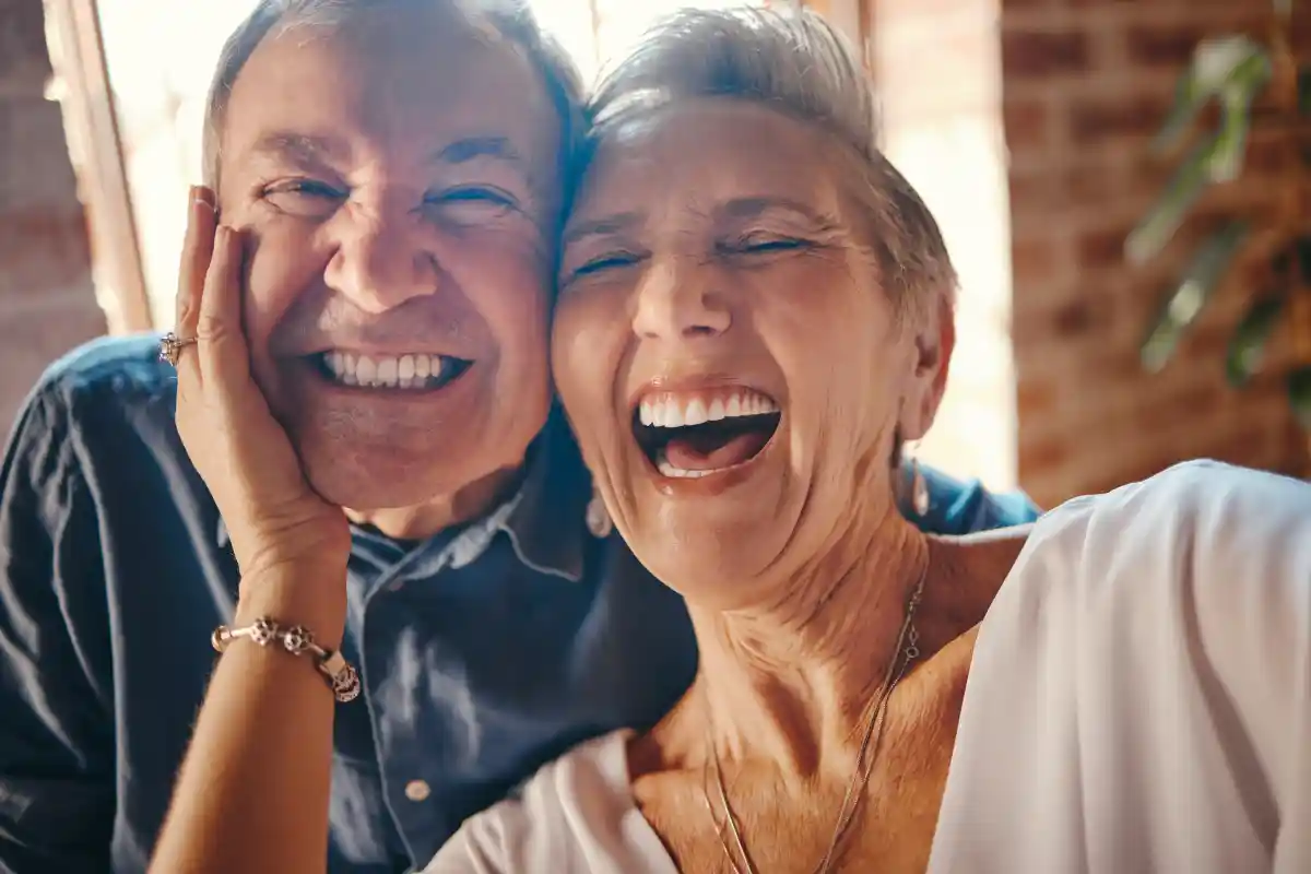 Dos personas sonrientes en un entorno acogedor.