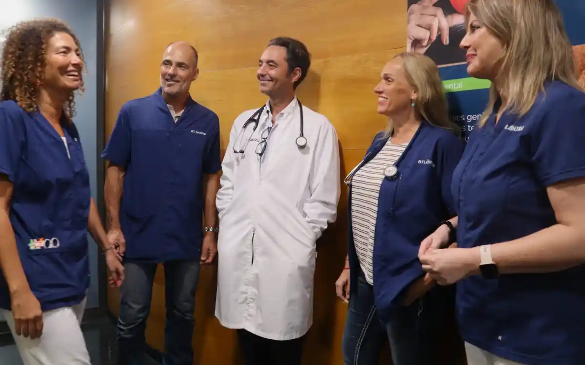 Un grupo de profesionales de la salud sonríe y se reúne en un entorno médico.