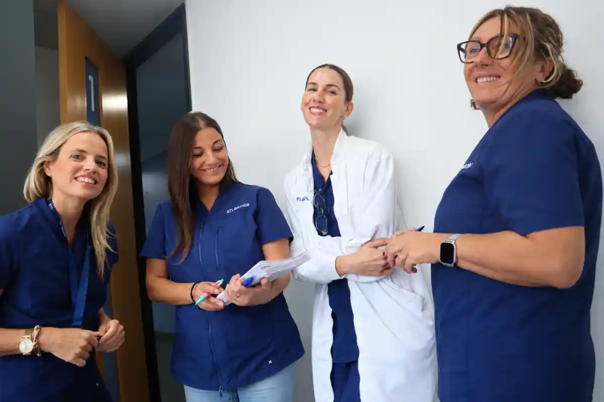 Cuatro profesionales de atención médica sonríen juntos.